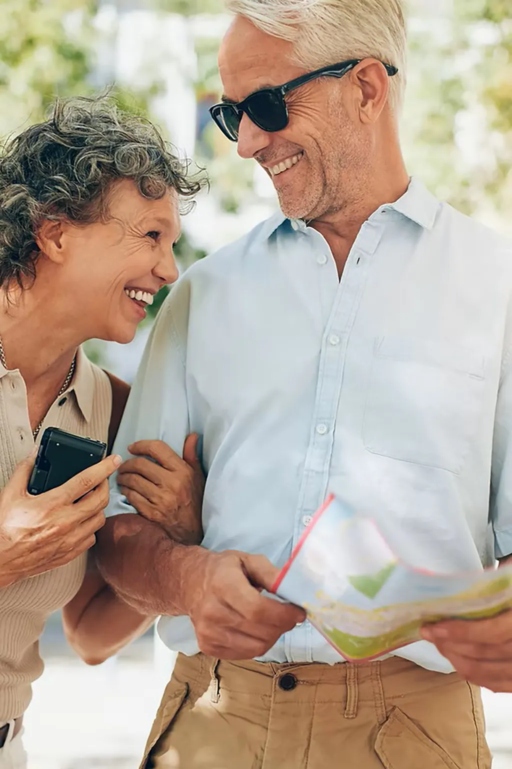 photo of a smiling senior couple with the woman holding the mans arm and laughing